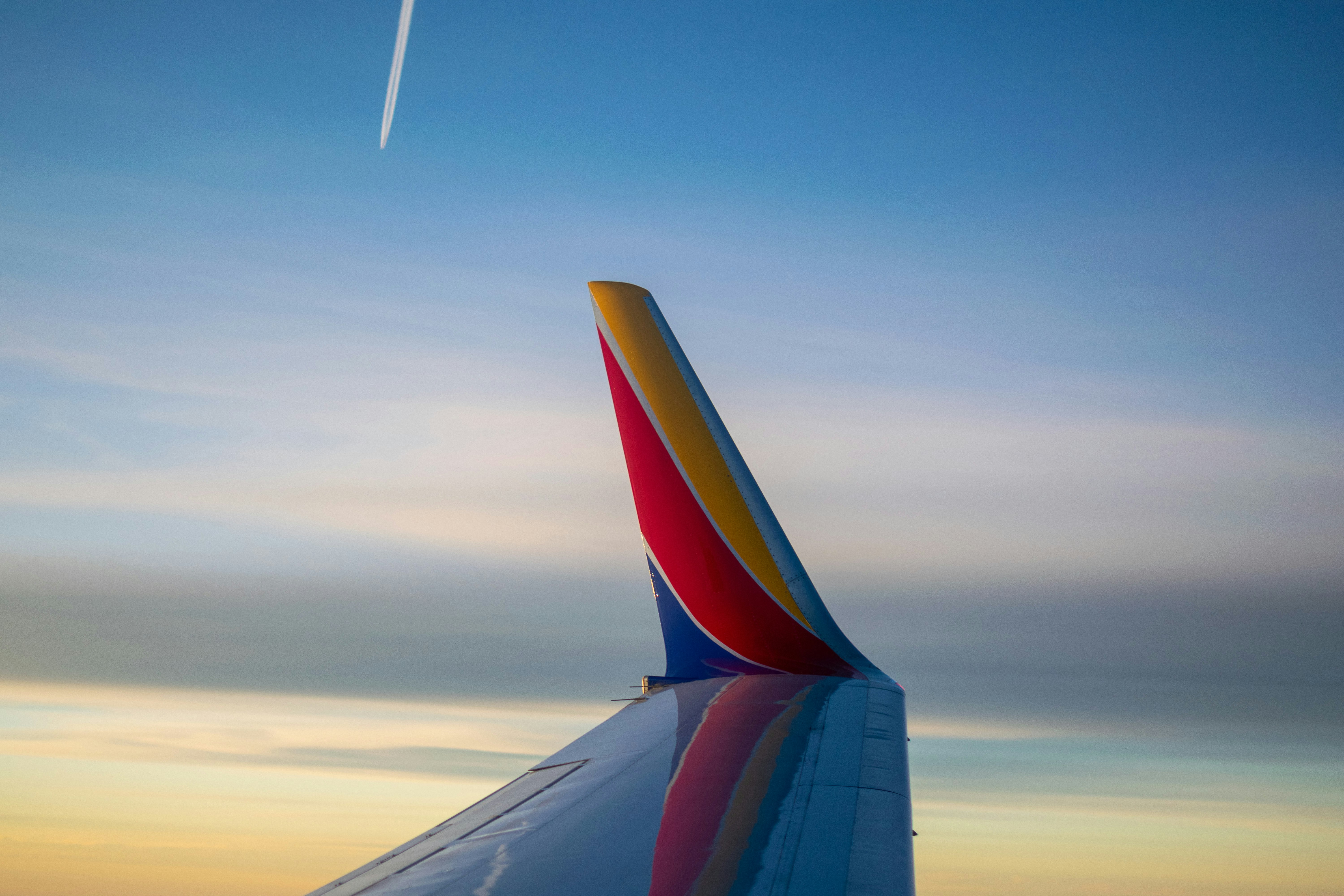 white, yellow, red, and blue passenger plane wing